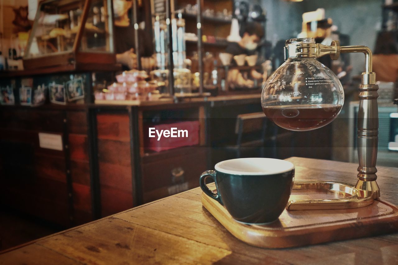 Coffee cup on wood table in old cafe