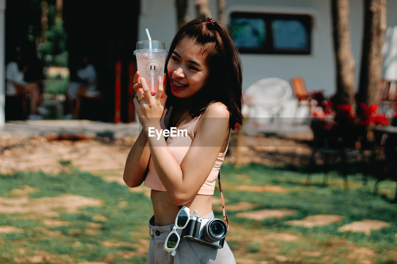 PORTRAIT OF BEAUTIFUL WOMAN STANDING IN FRONT OF A SMILING YOUNG MAN