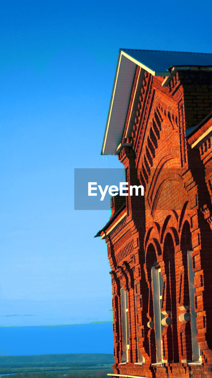 Low angle view of temple against clear blue sky