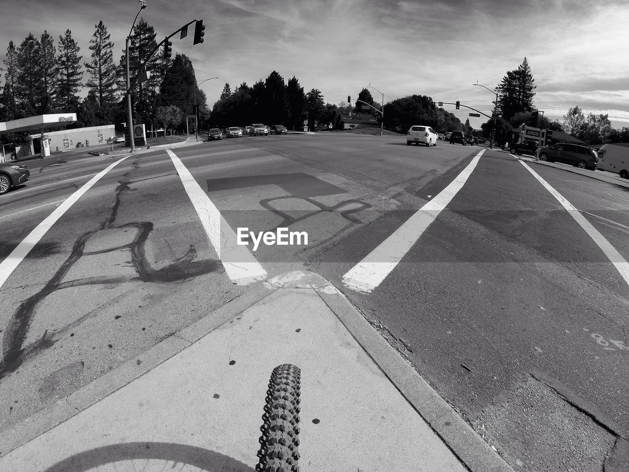 Fish-eye view of cars on road intersection against sky