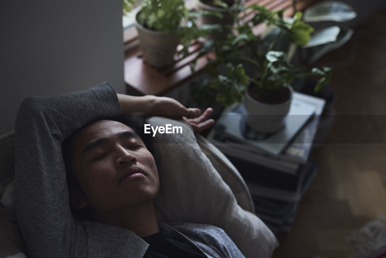 Sad man facing depression lying in bed