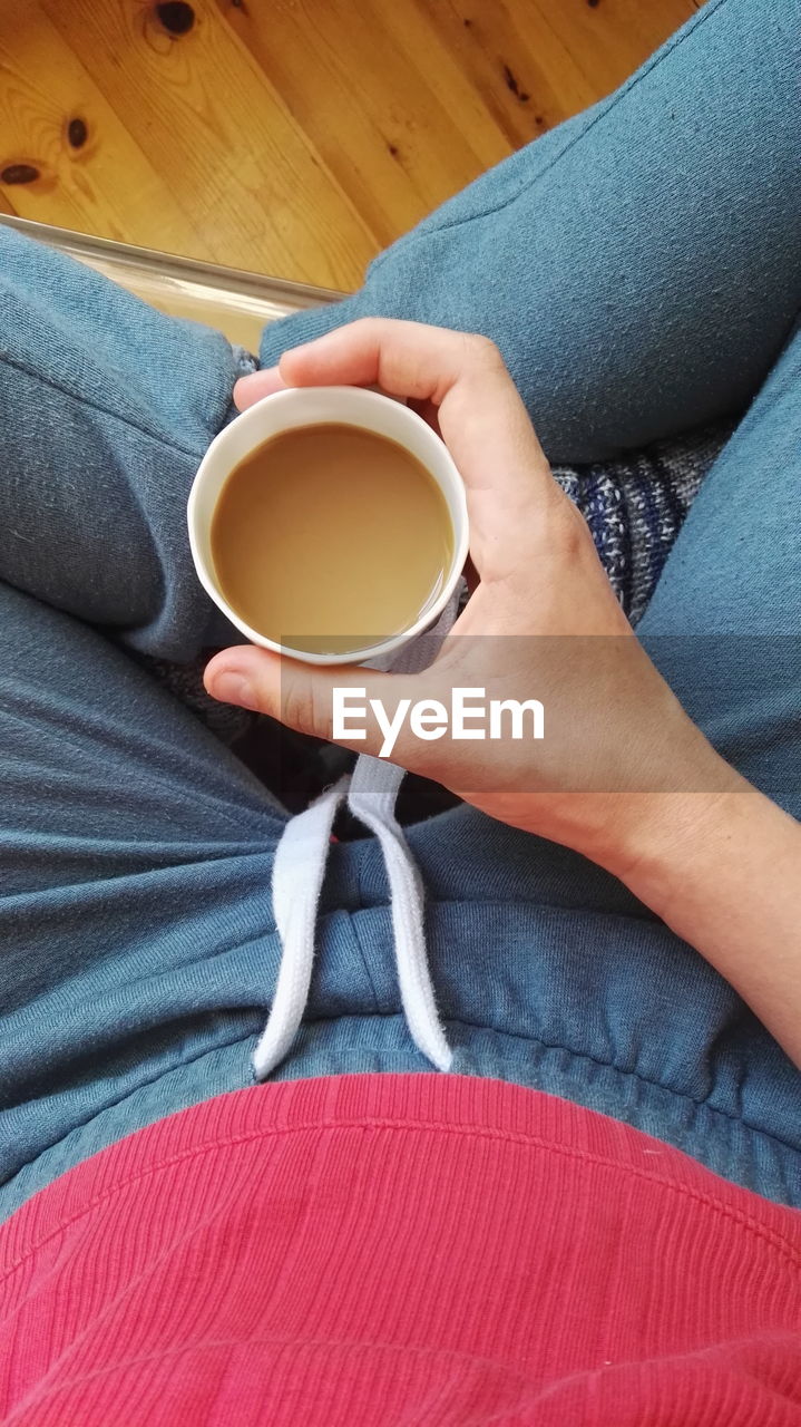 High angle view of woman holding cup of tea 