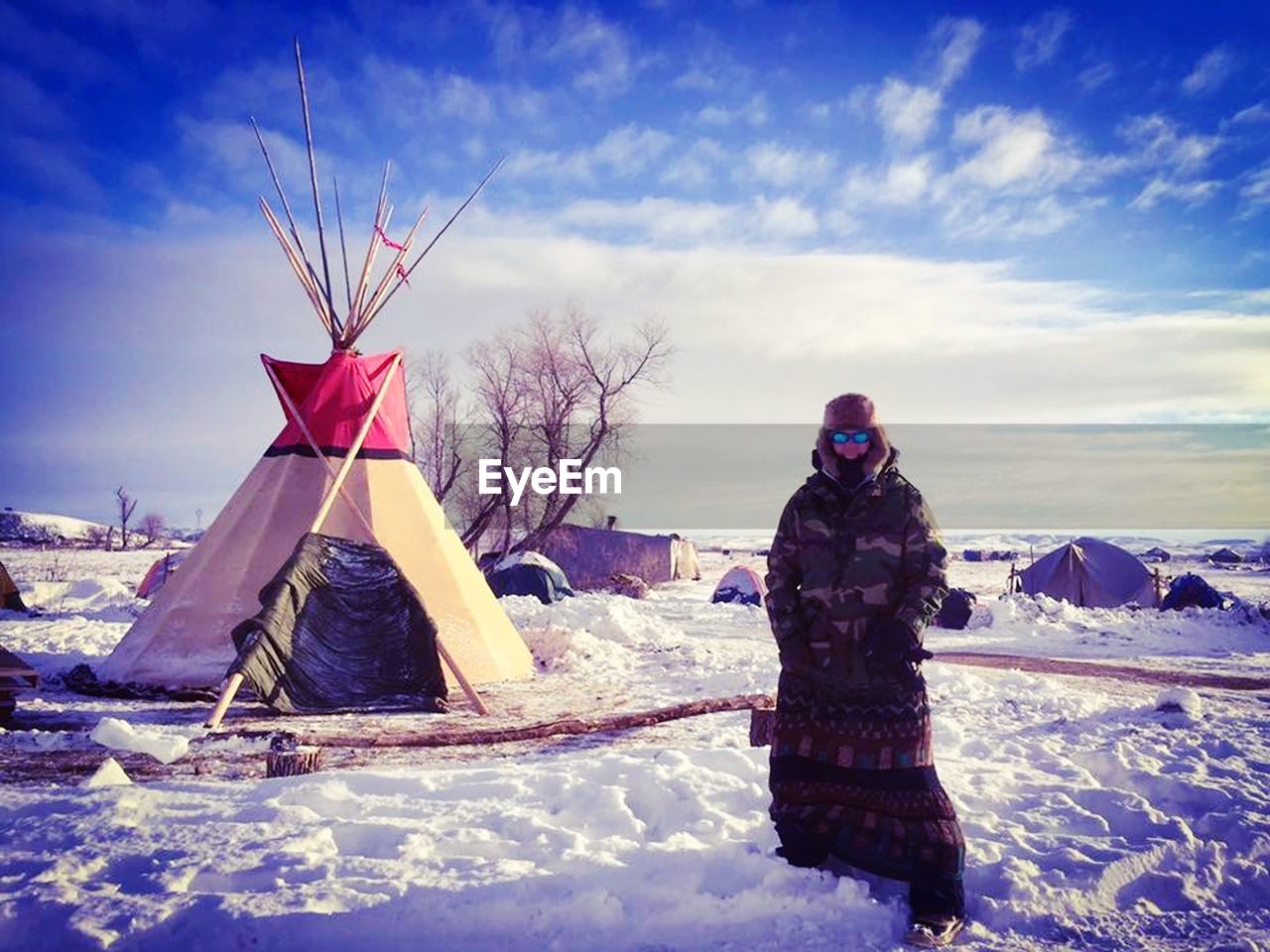 Man standing on snow covered field against sky