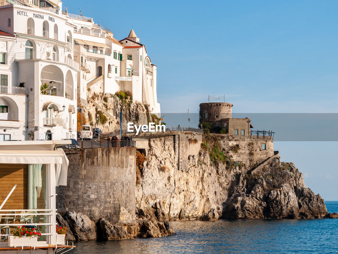 Buildings by sea against sky in city