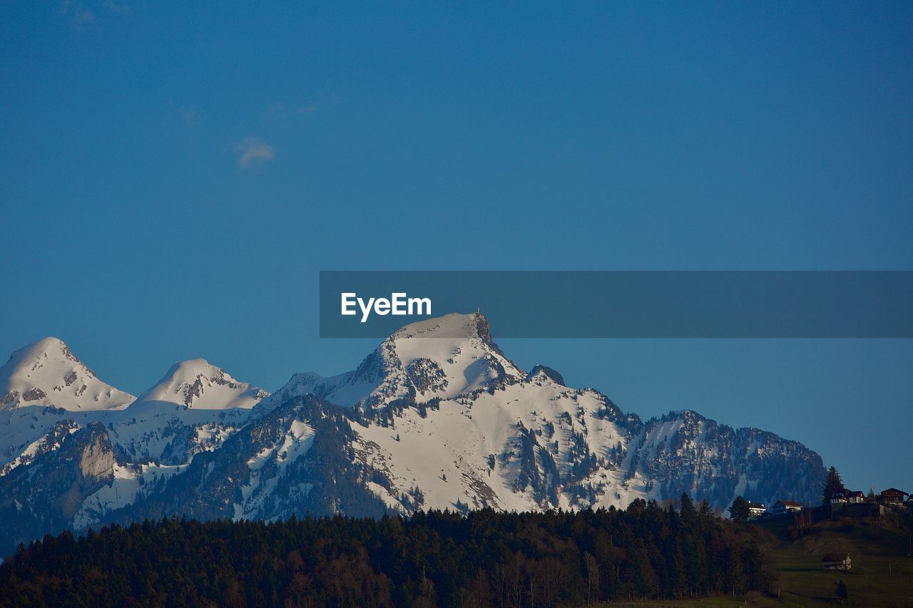 SCENIC VIEW OF SNOWCAPPED MOUNTAIN AGAINST BLUE SKY