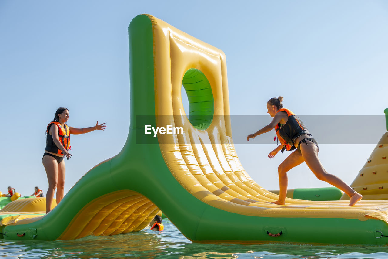 Inflatable bounce castle floats in park for children having fun in water with attractions in the sea