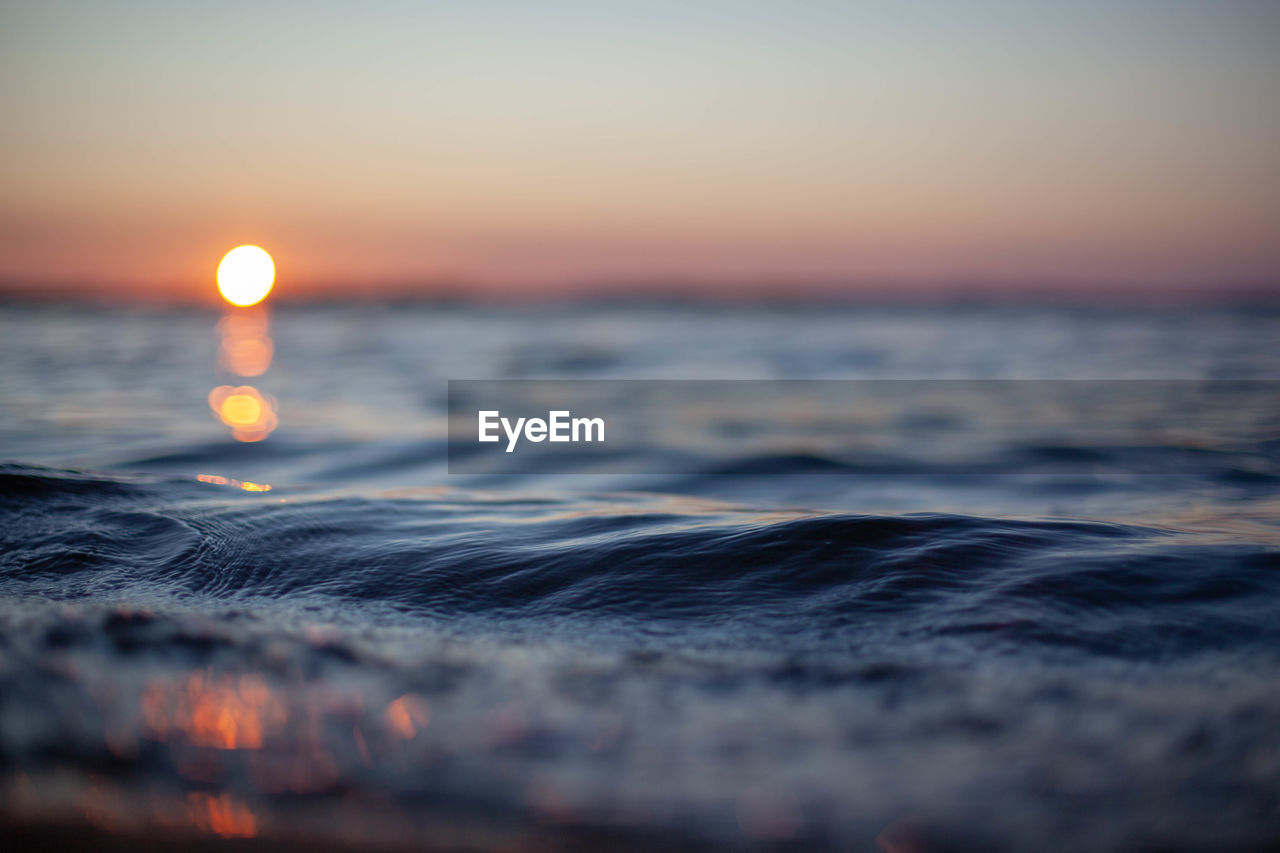 Close-up of sea wave against sky during sunset