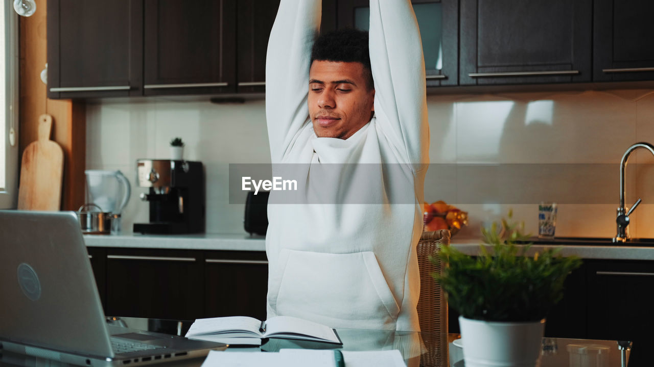 portrait of young woman exercising in kitchen