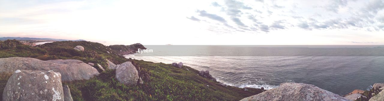 SCENIC VIEW OF SEA BY ROCKS AGAINST SKY