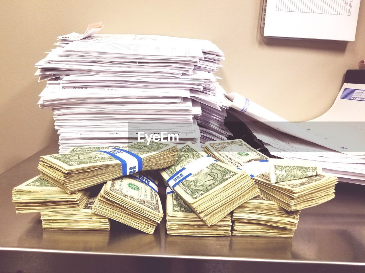 Stack of currencies and papers on table