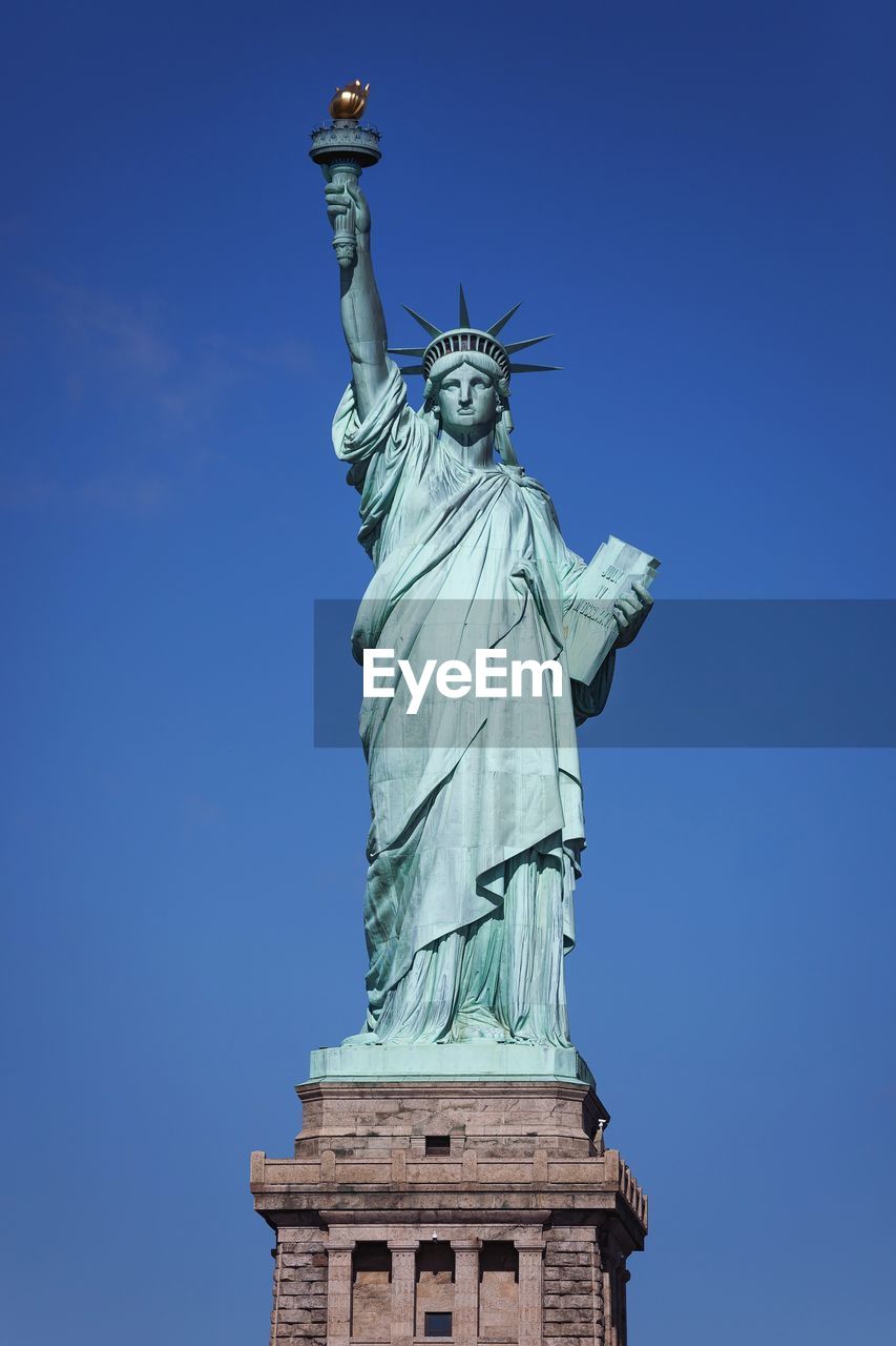 Statue of liberty against clear blue sky during sunny day