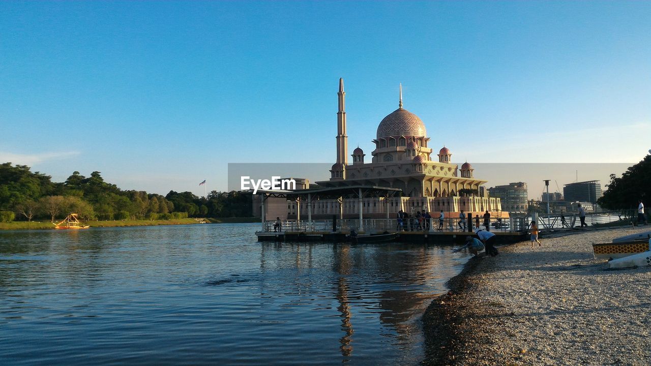 Putra mosque by river against clear sky on sunny day