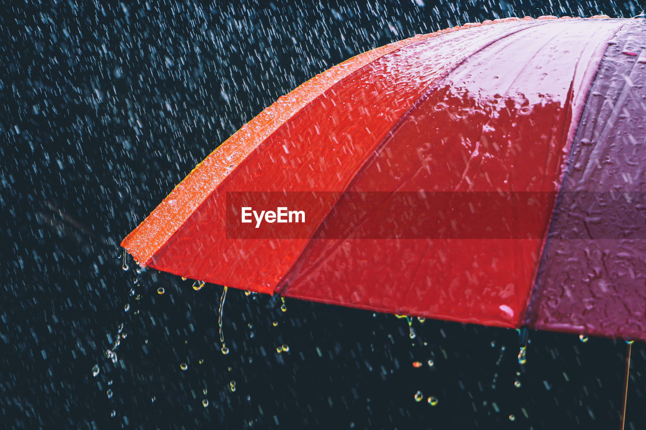 Close-up of wet red umbrella during monsoon