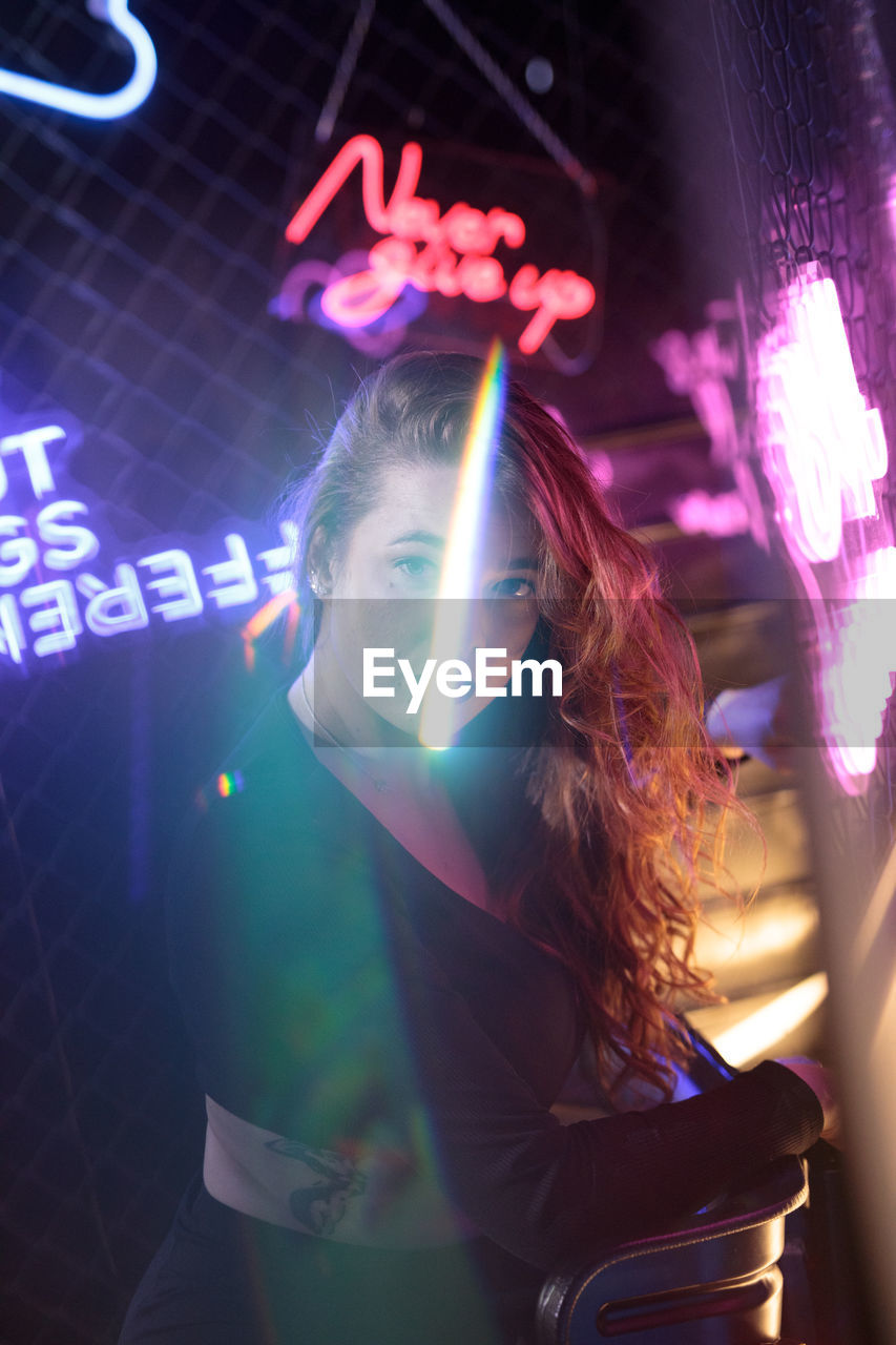 cropped image of woman holding illuminated christmas tree at night