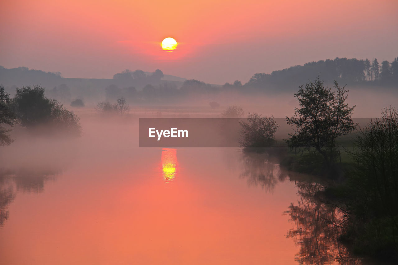 Scenic view of lake against sky during sunset