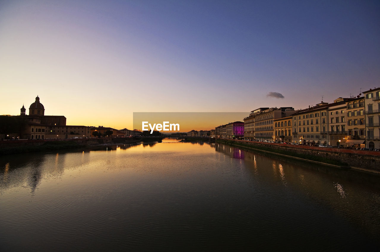 VIEW OF RIVER WITH BUILDINGS IN BACKGROUND