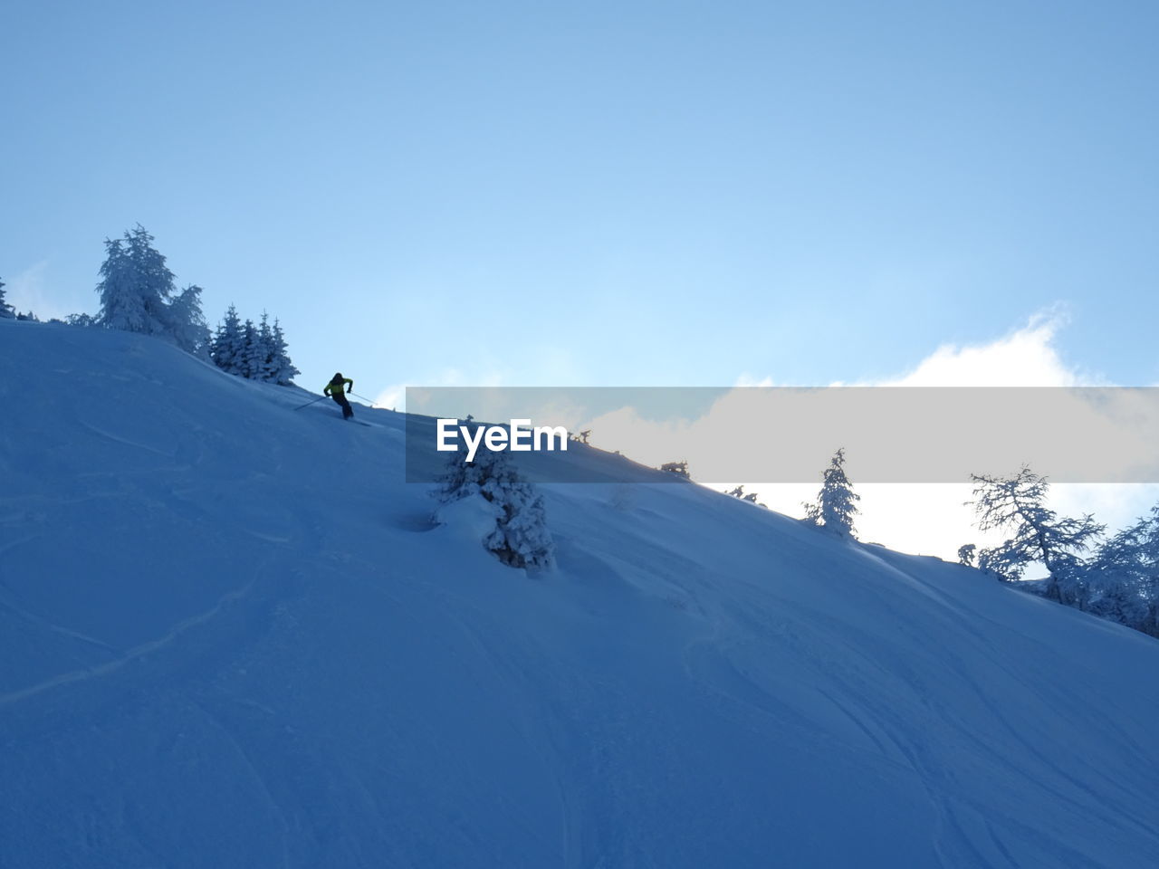 Person skiing on snowcapped mountain against sky