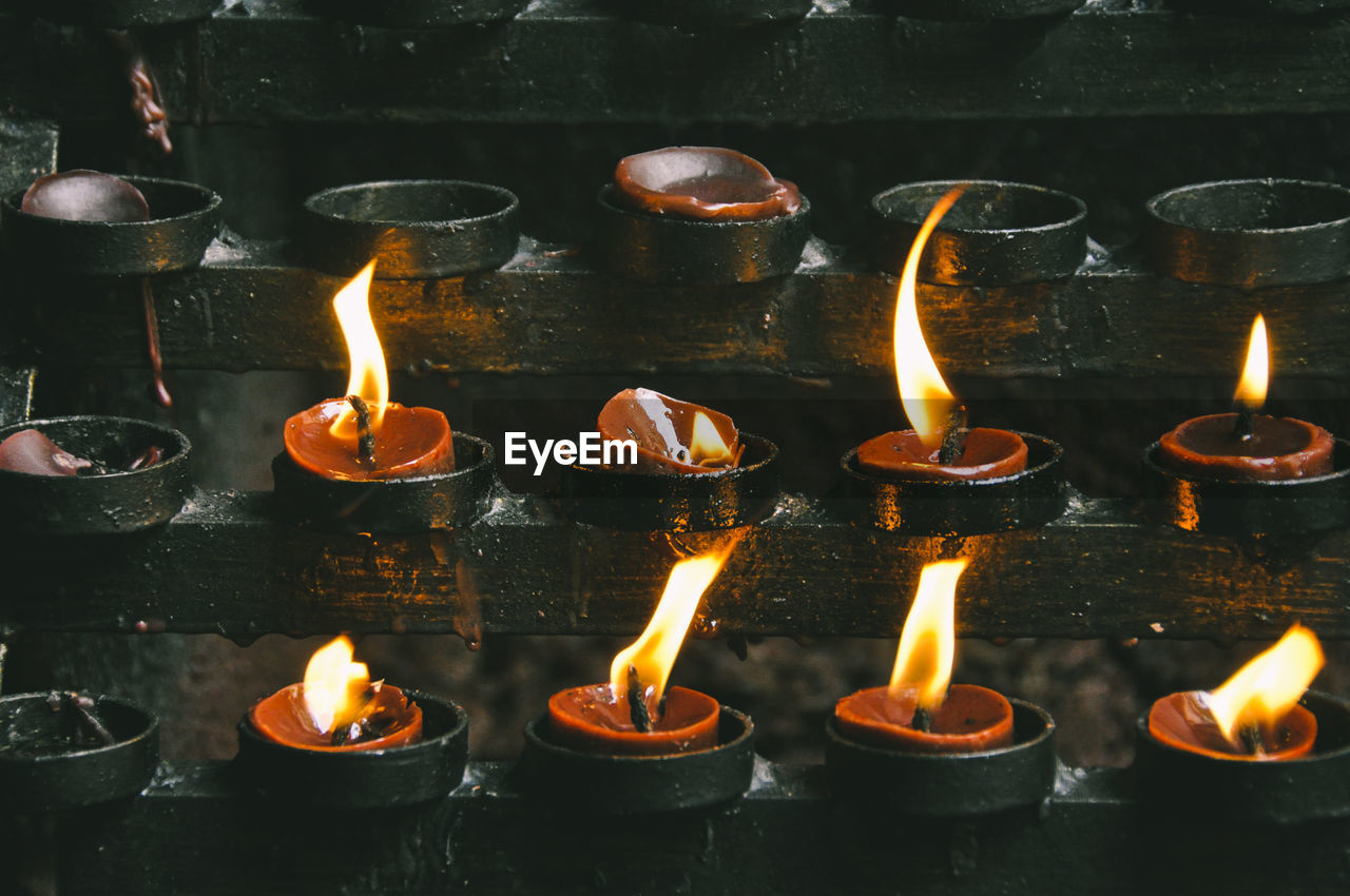 Full frame shot of burning candles in temple