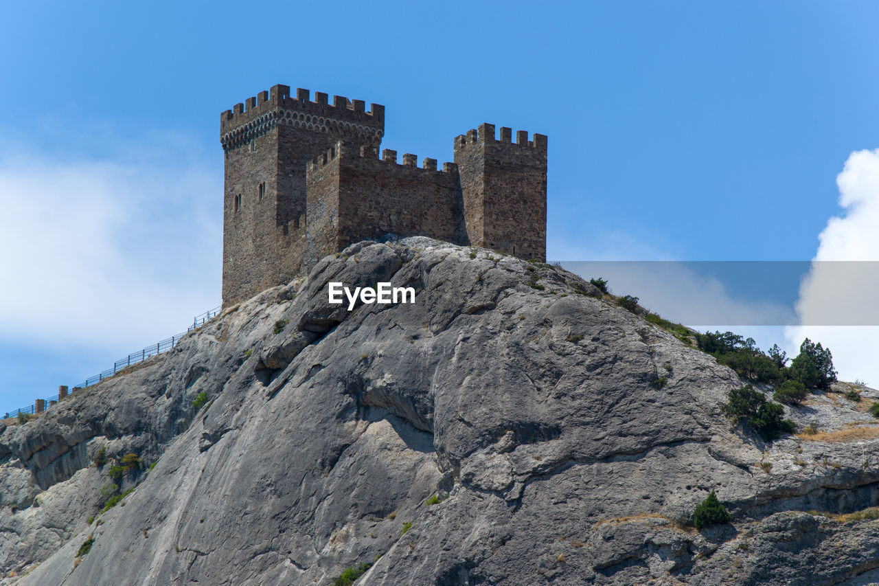 LOW ANGLE VIEW OF CASTLE ON MOUNTAIN AGAINST SKY