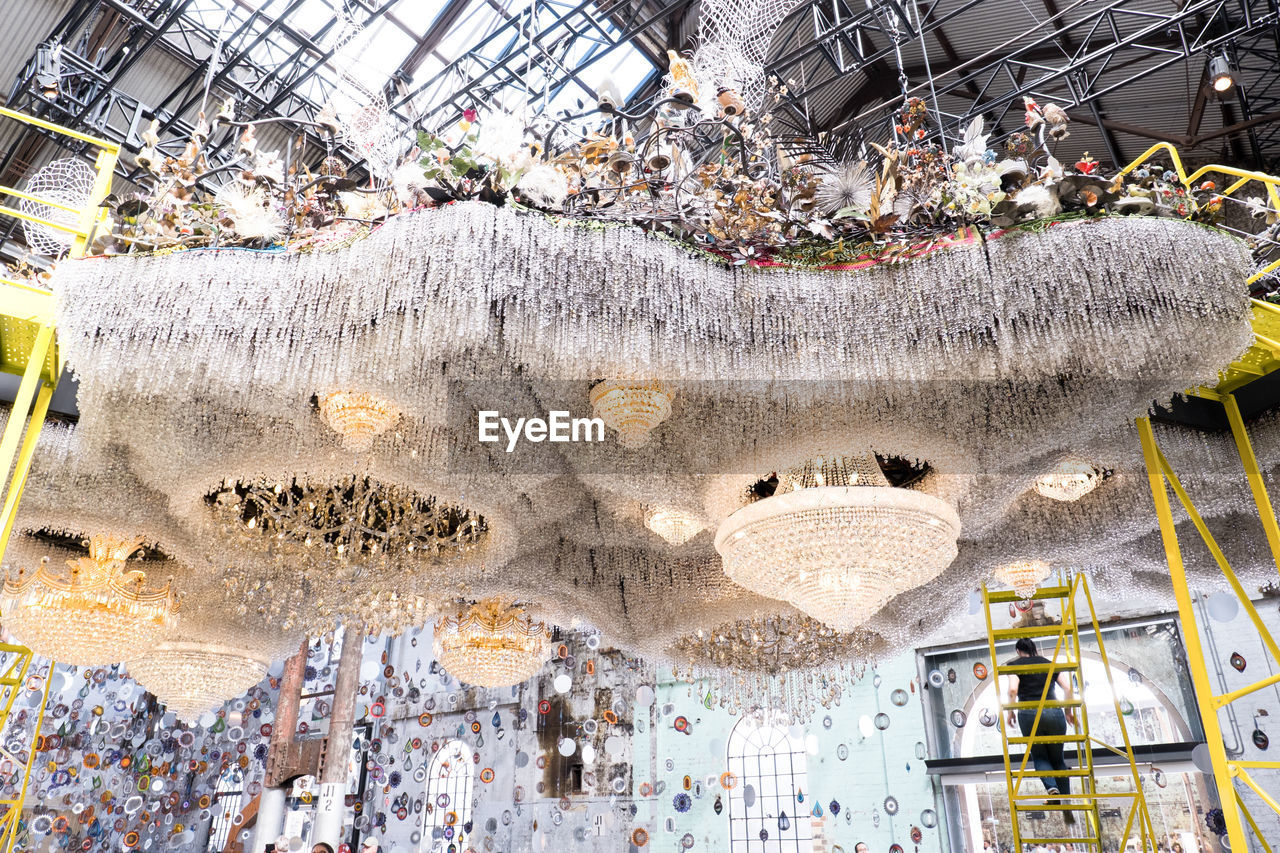 LOW ANGLE VIEW OF CHANDELIER HANGING FROM CEILING