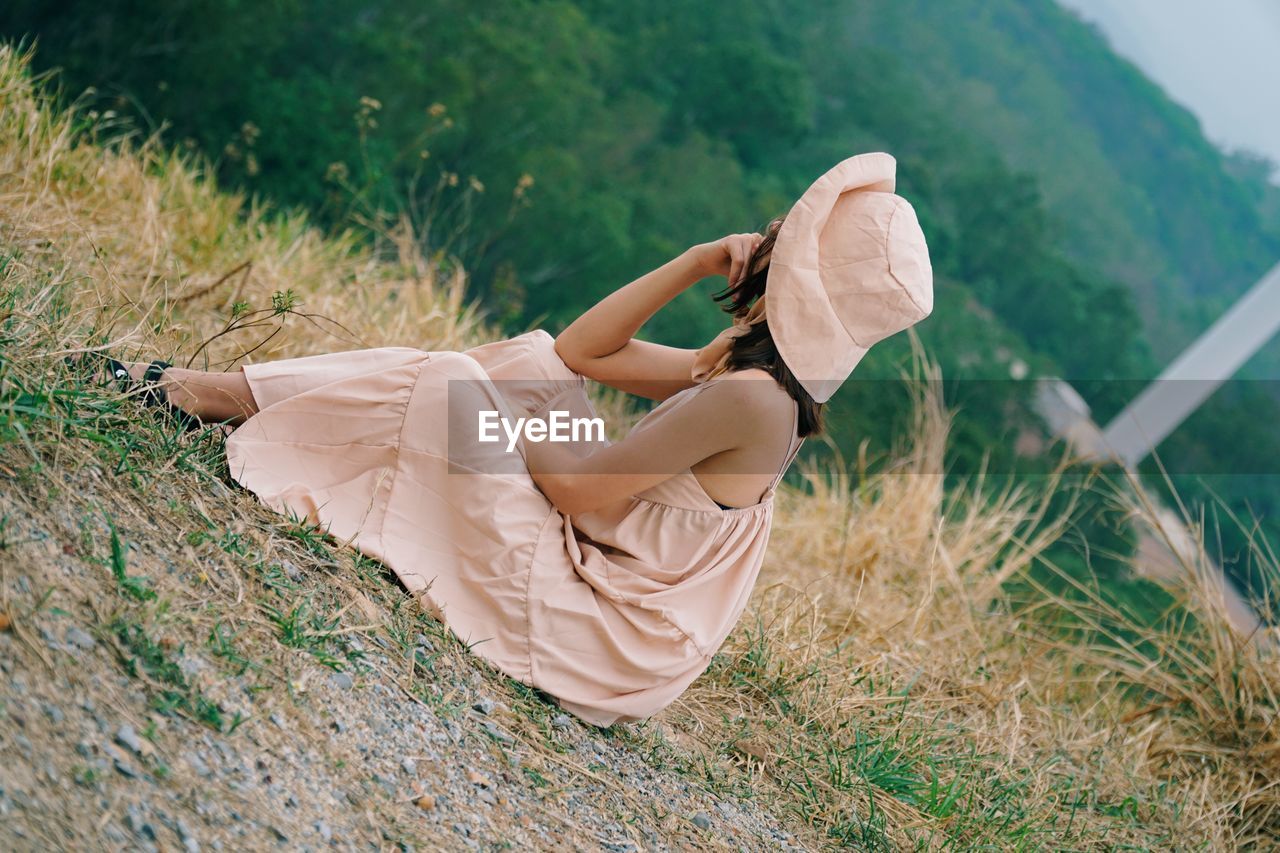 HIGH ANGLE VIEW OF WOMAN LYING ON FIELD