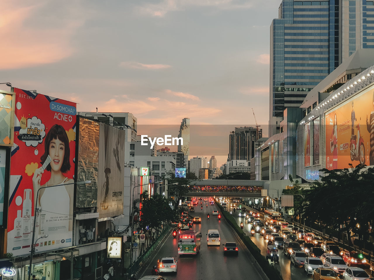 CITY STREET AMIDST BUILDINGS AGAINST SKY DURING SUNSET