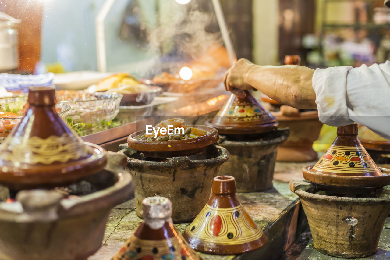 MAN PREPARING FOOD AT MARKET