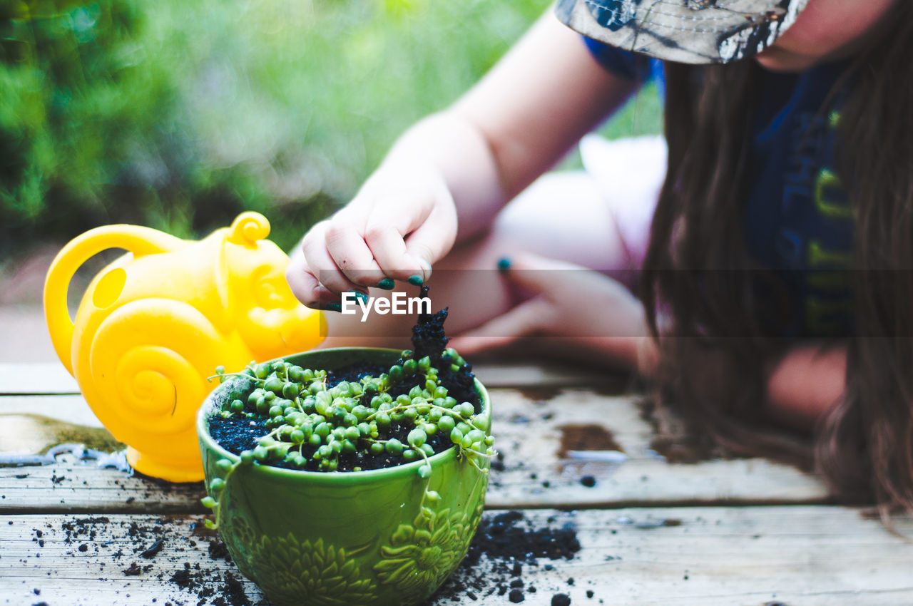 Girl planting plant in yard