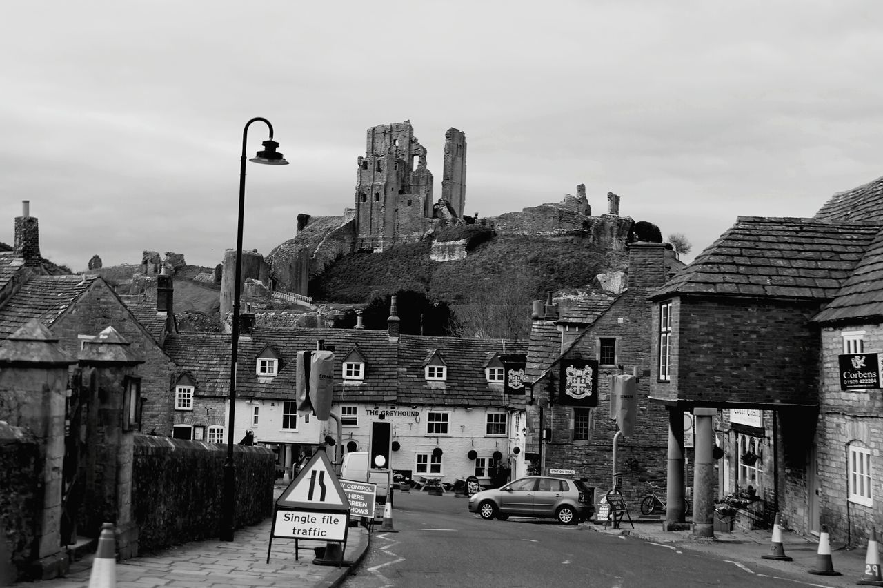 Road in town by corfe castle against sky