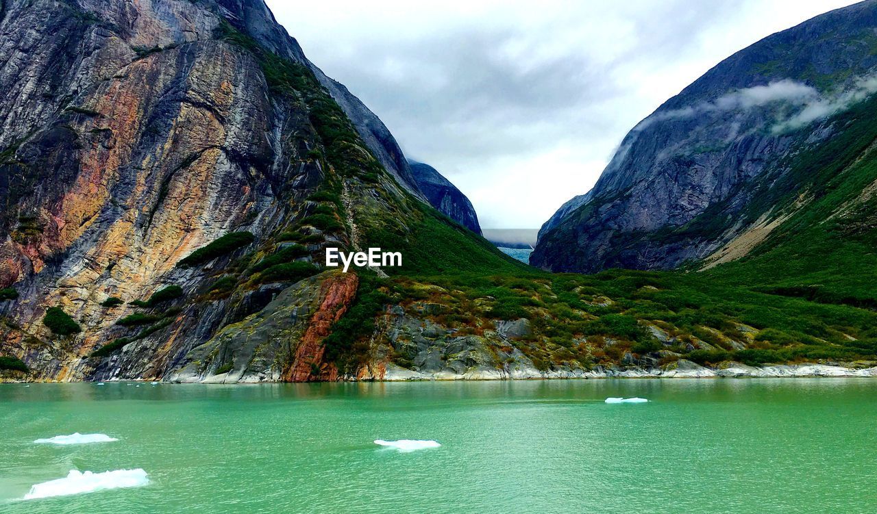 SCENIC VIEW OF LAKE BY MOUNTAIN AGAINST SKY