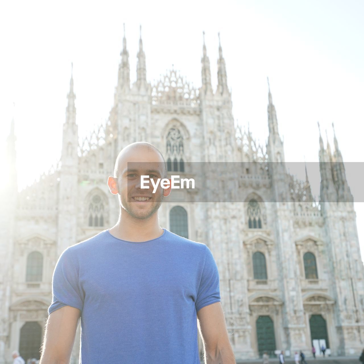 Low angle portrait of smiling man standing against milan cathedral