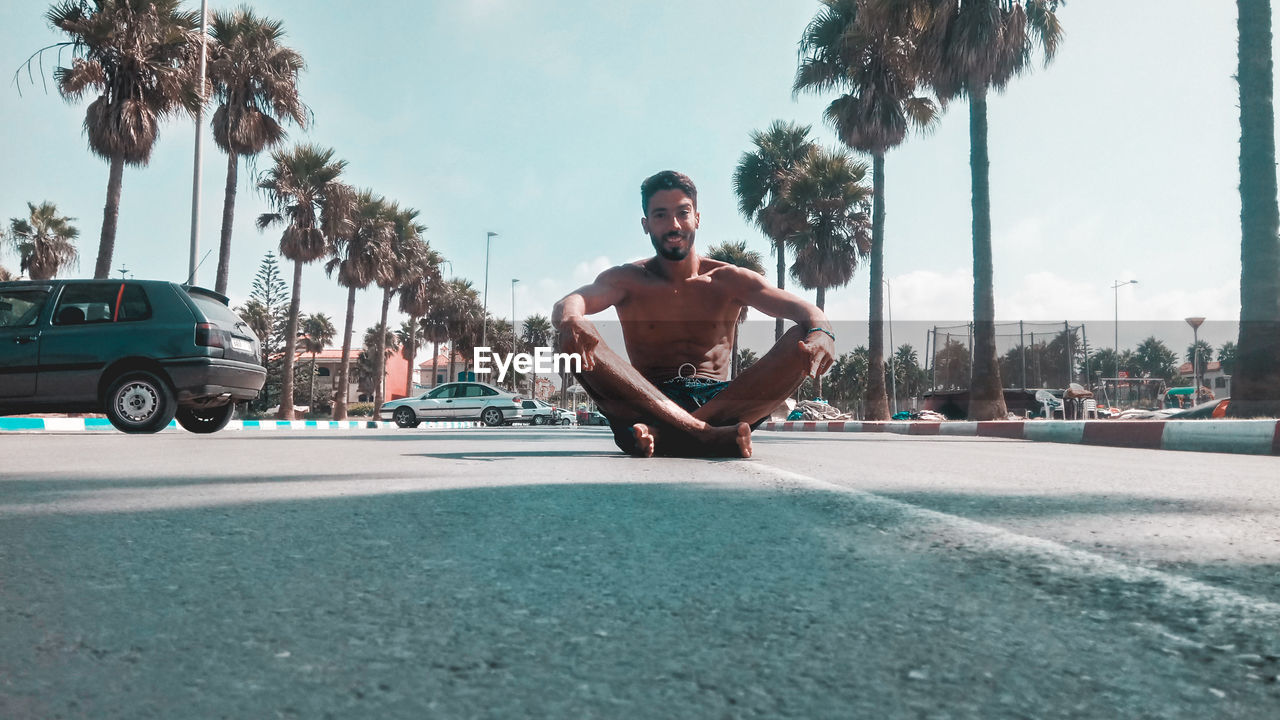 FULL LENGTH OF MAN ON STREET AGAINST SKY