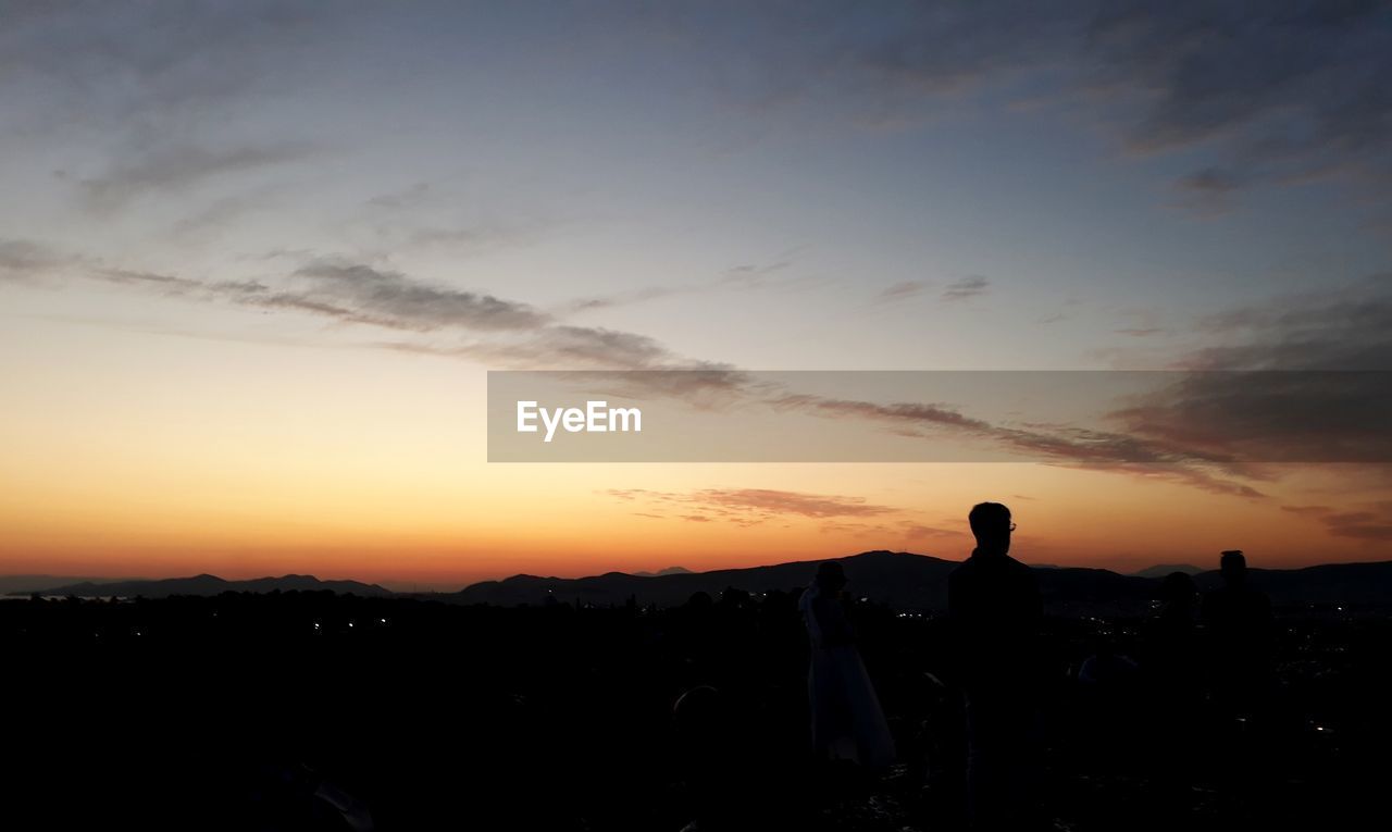 SILHOUETTE PEOPLE STANDING AGAINST SKY DURING SUNSET