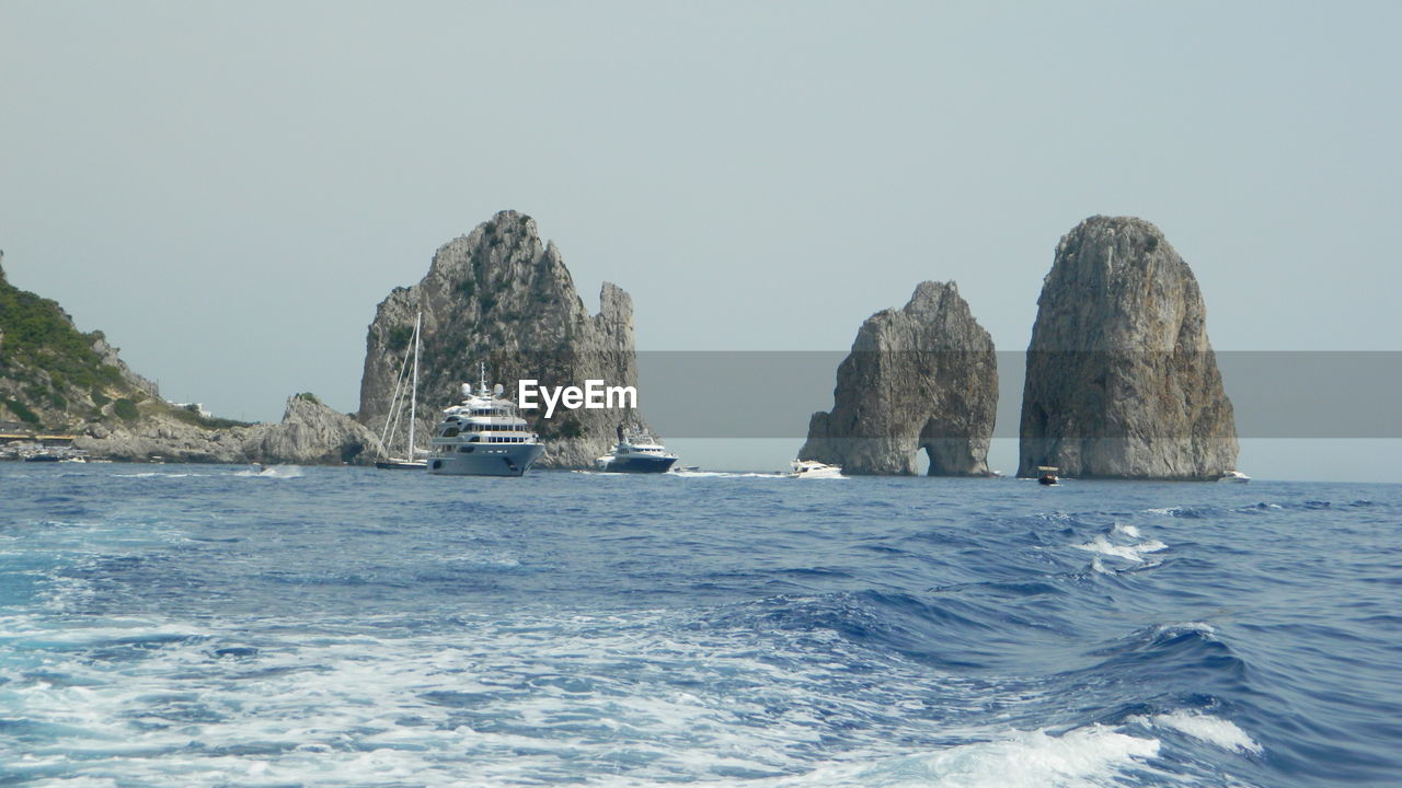 Scenic view of rock formation in sea against clear sky