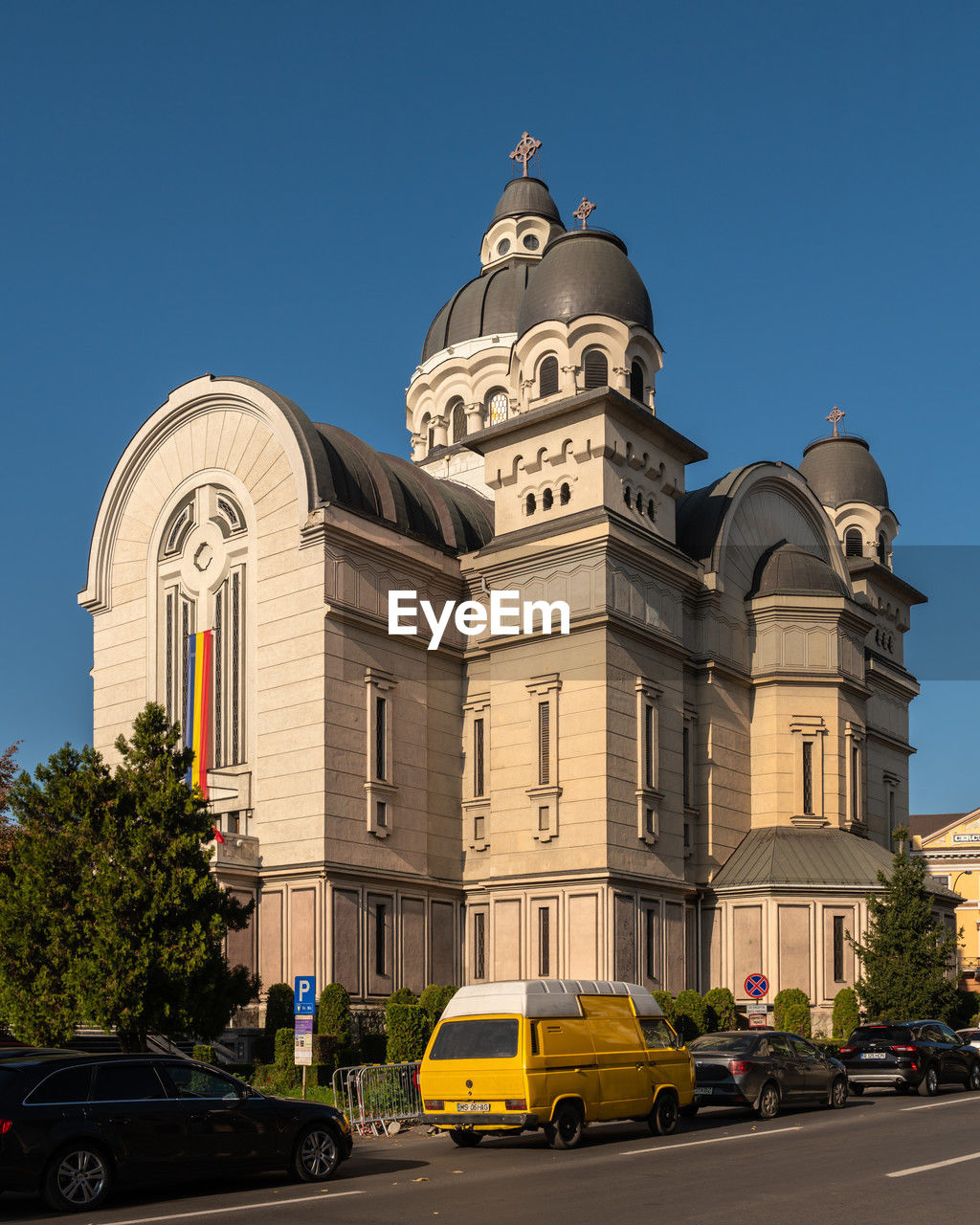 architecture, building exterior, built structure, city, car, transportation, mode of transportation, motor vehicle, landmark, travel destinations, sky, street, building, travel, nature, vehicle, clear sky, blue, place of worship, history, religion, the past, dome, sunny, road, city street, no people, tourism, belief, tower, day, downtown, land vehicle, outdoors, taxi, tree, plant