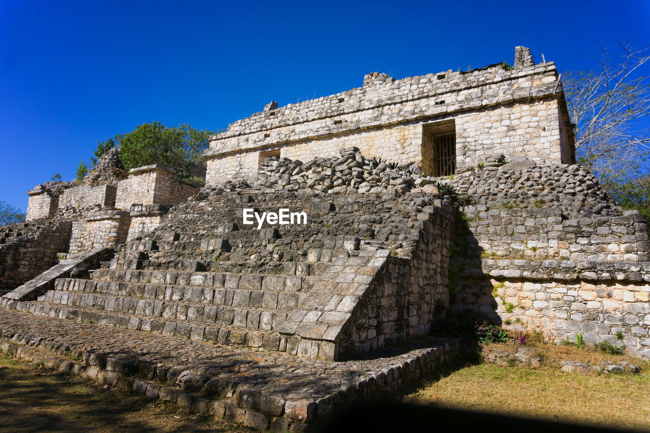 LOW ANGLE VIEW OF OLD RUIN BUILDING AGAINST BLUE SKY