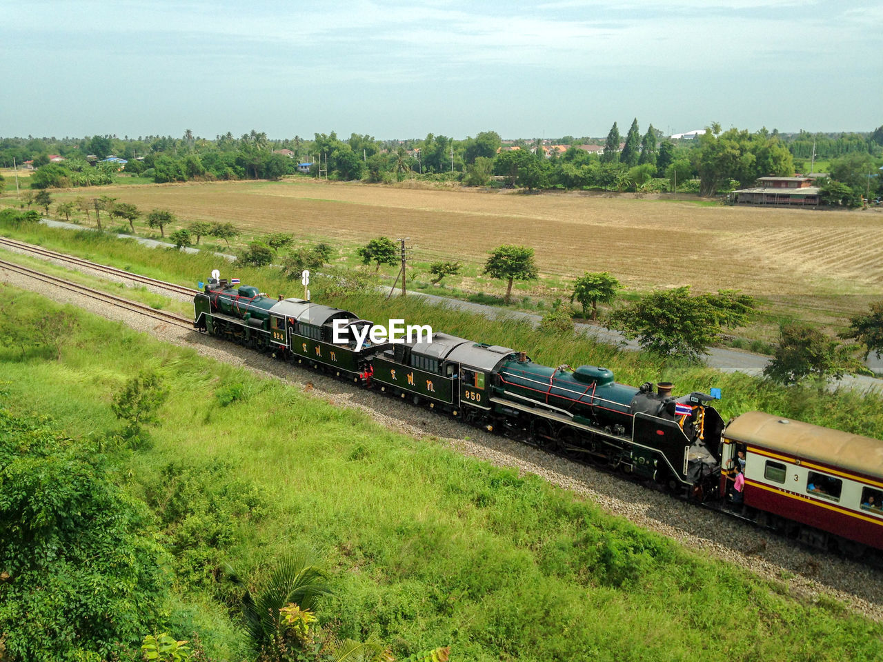 HIGH ANGLE VIEW OF TRAIN ON RAILROAD TRACKS AGAINST SKY