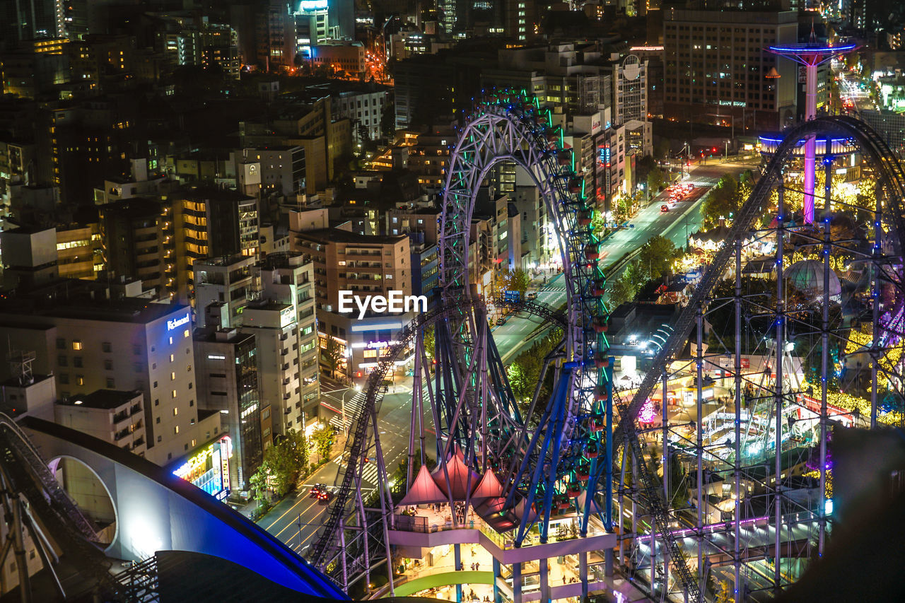 HIGH ANGLE VIEW OF ILLUMINATED FERRIS WHEEL IN CITY