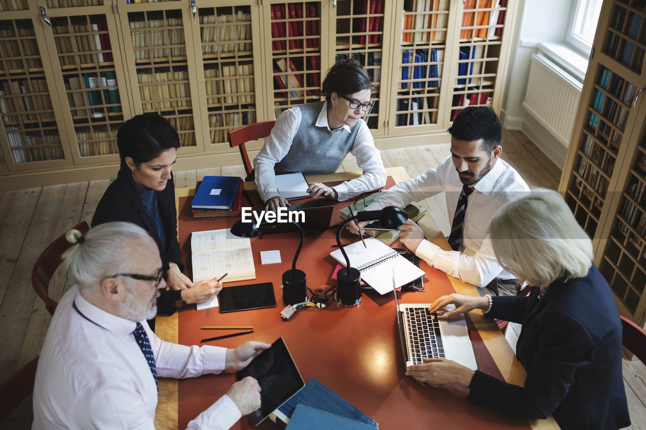 High angle view of professionals working at table in law library