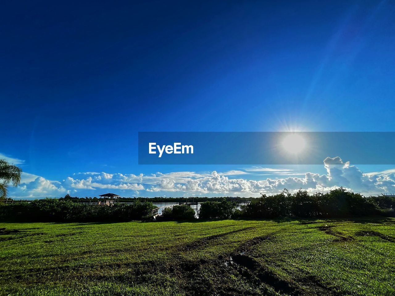 sky, horizon, sunlight, landscape, environment, plant, scenics - nature, nature, beauty in nature, land, field, blue, grass, cloud, tranquility, green, tranquil scene, no people, mountain, rural scene, morning, agriculture, sunbeam, outdoors, tree, lens flare, growth, clear sky, sun, meadow, light, farm, idyllic, day, dusk, plain, sunny, reflection, grassland
