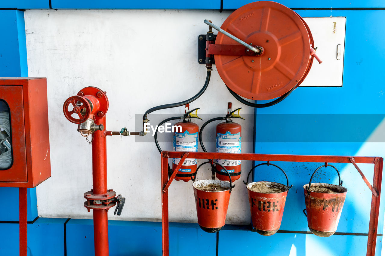 CLOSE-UP OF FIRE HYDRANT AGAINST WALL