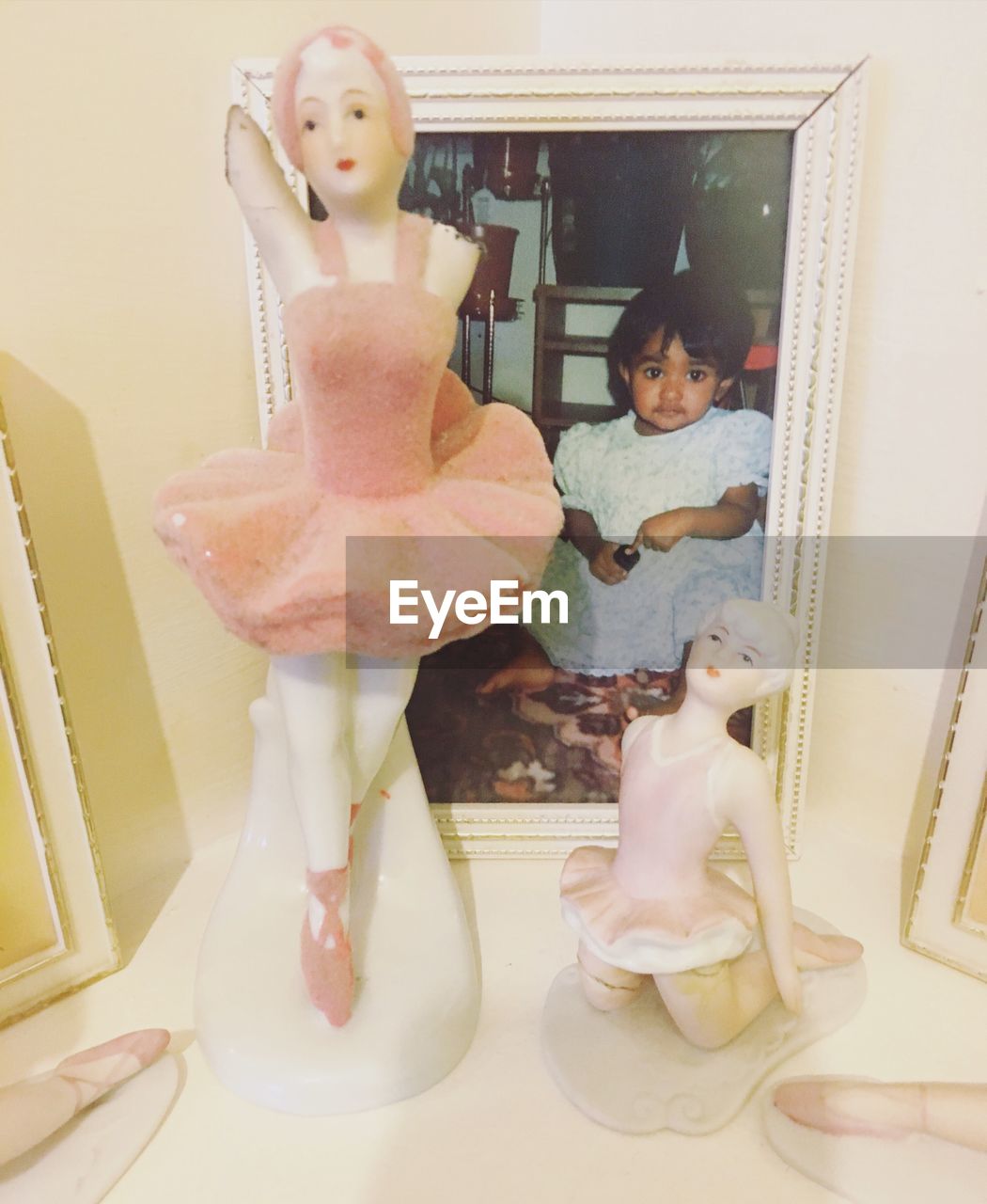 Close-up of ballerina figurines by picture frame on table