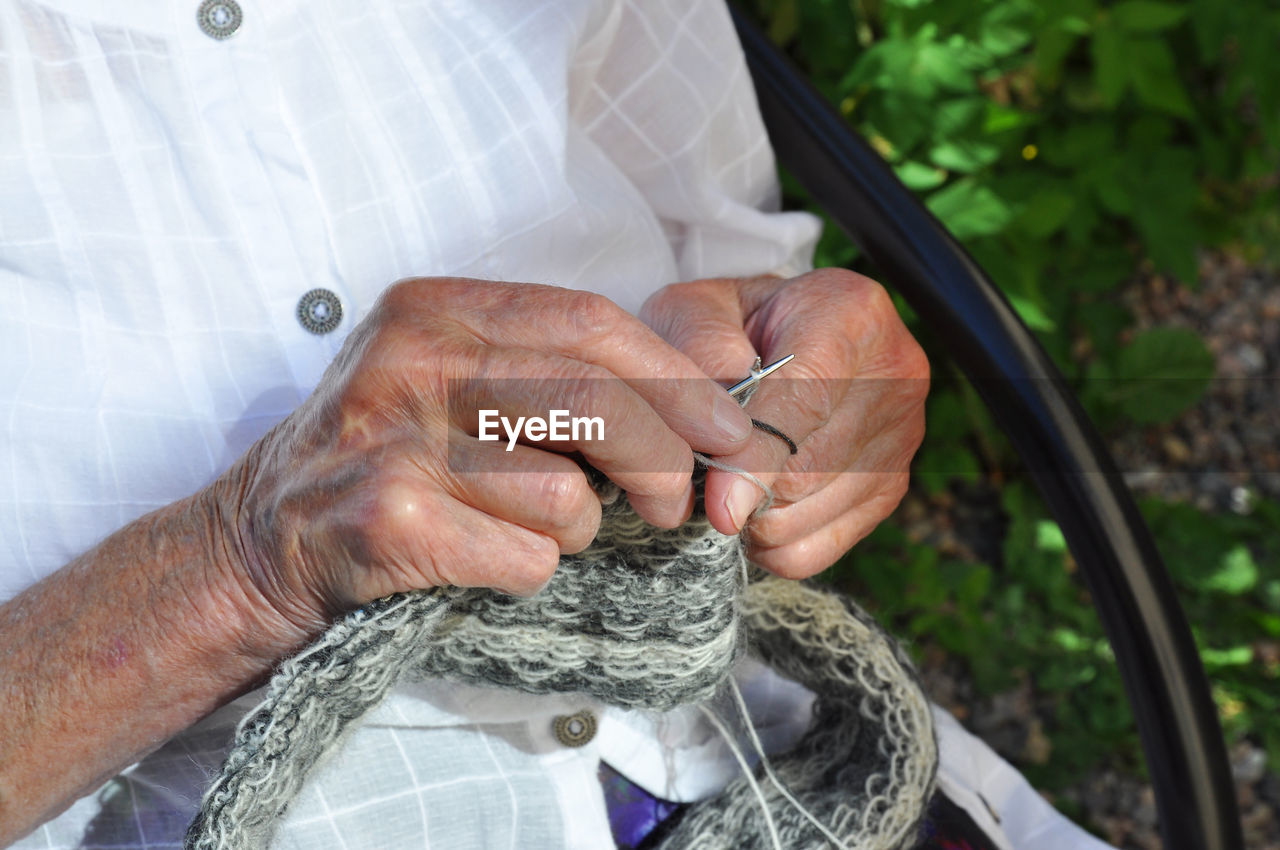 Directly above shot of smart phone and notepad with writing instruments on white background