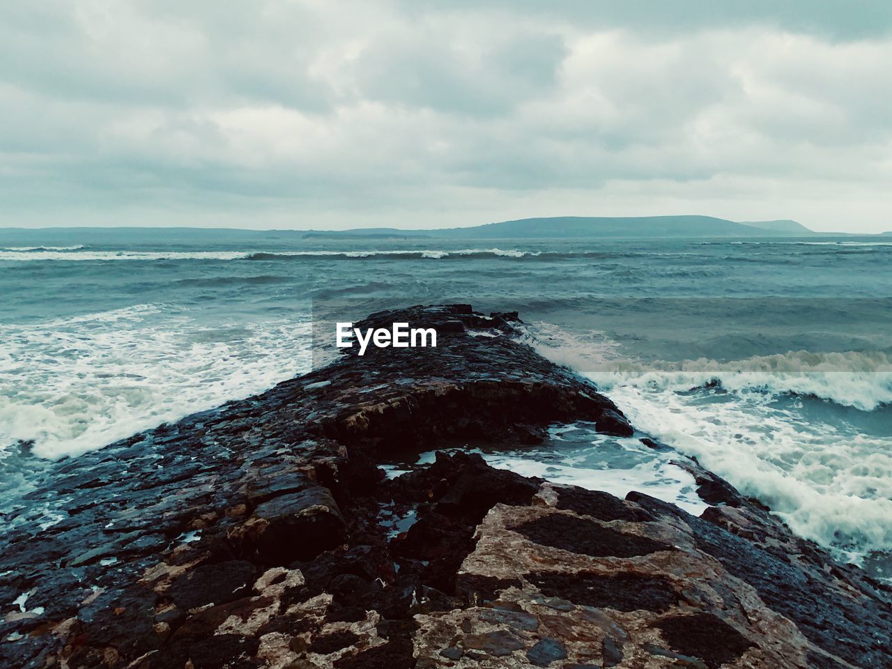 SCENIC VIEW OF ROCKS ON BEACH AGAINST SKY
