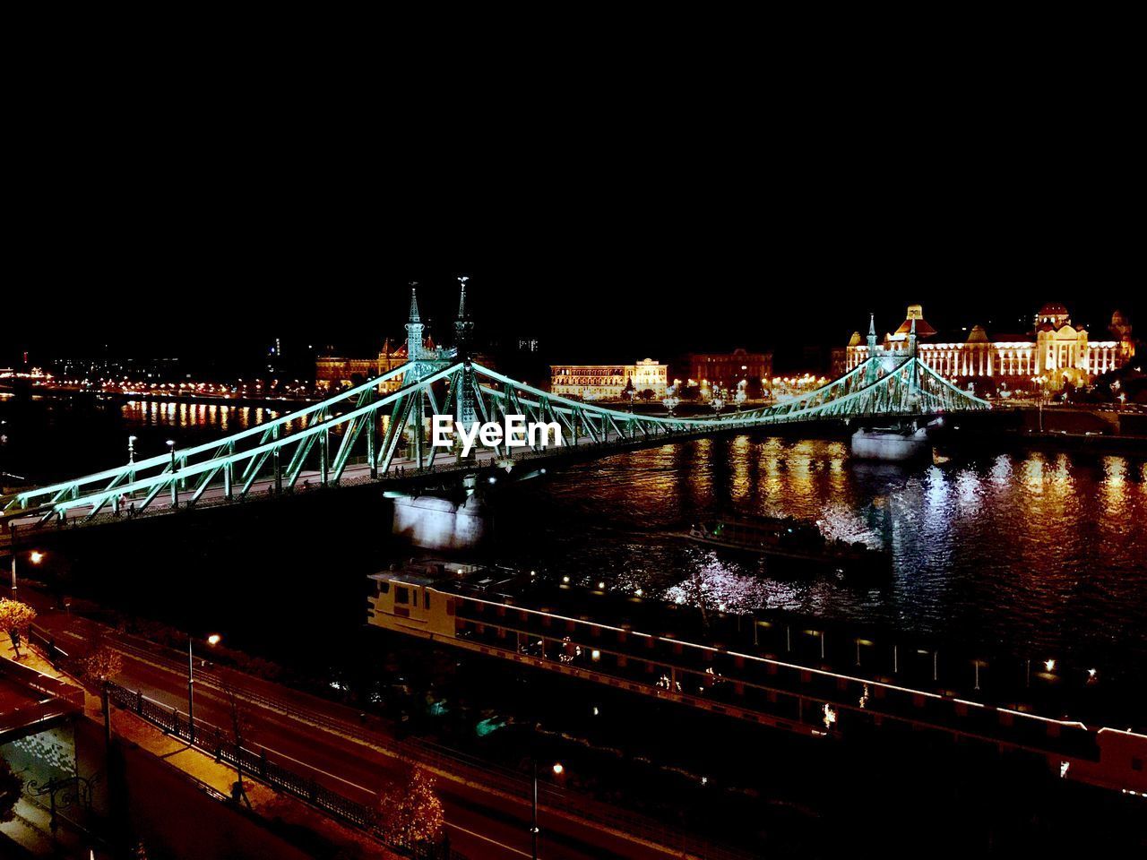 ILLUMINATED SUSPENSION BRIDGE OVER RIVER