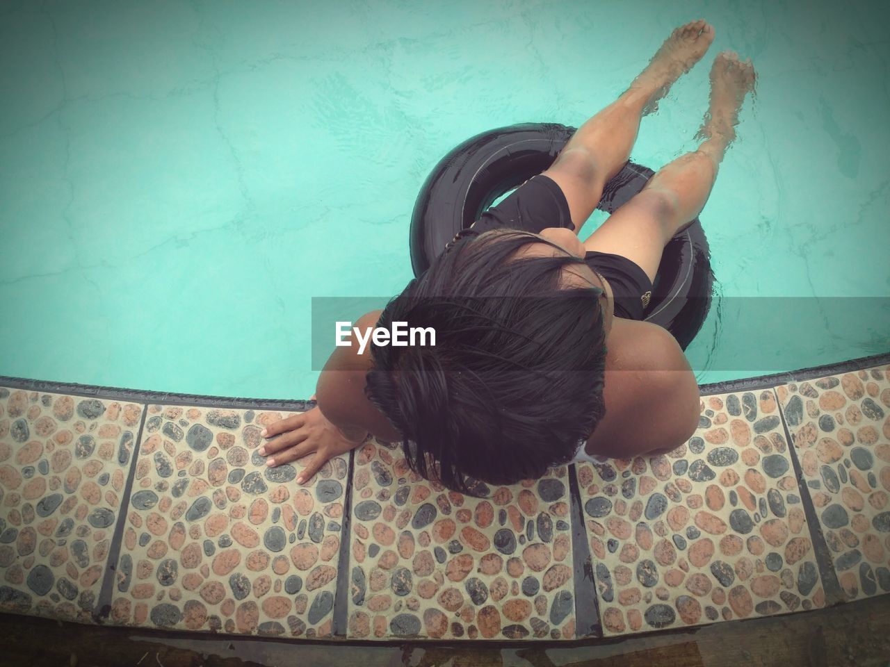 HIGH ANGLE VIEW OF CHILD SWIMMING IN POOL