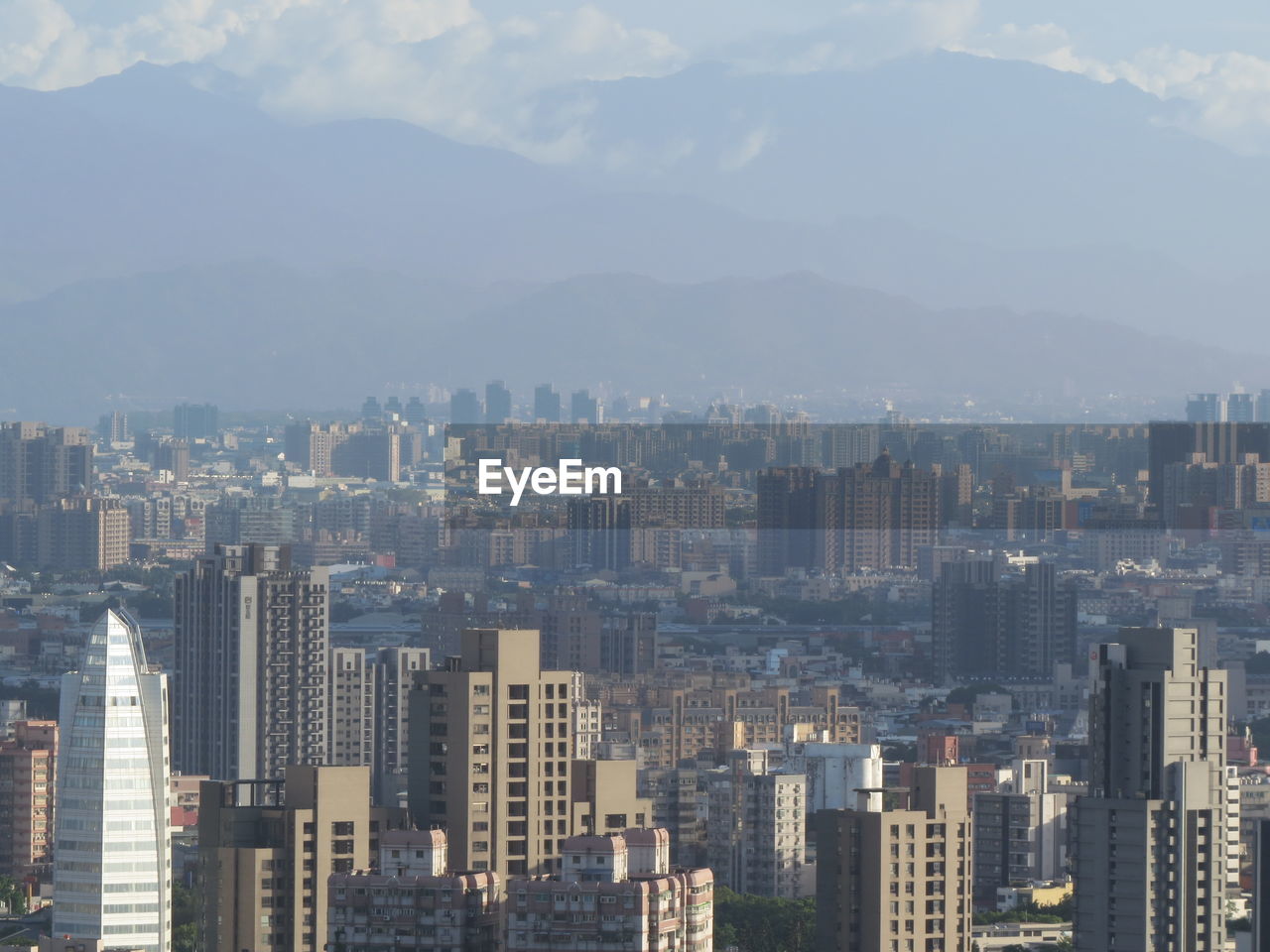 Aerial view of buildings in city against sky