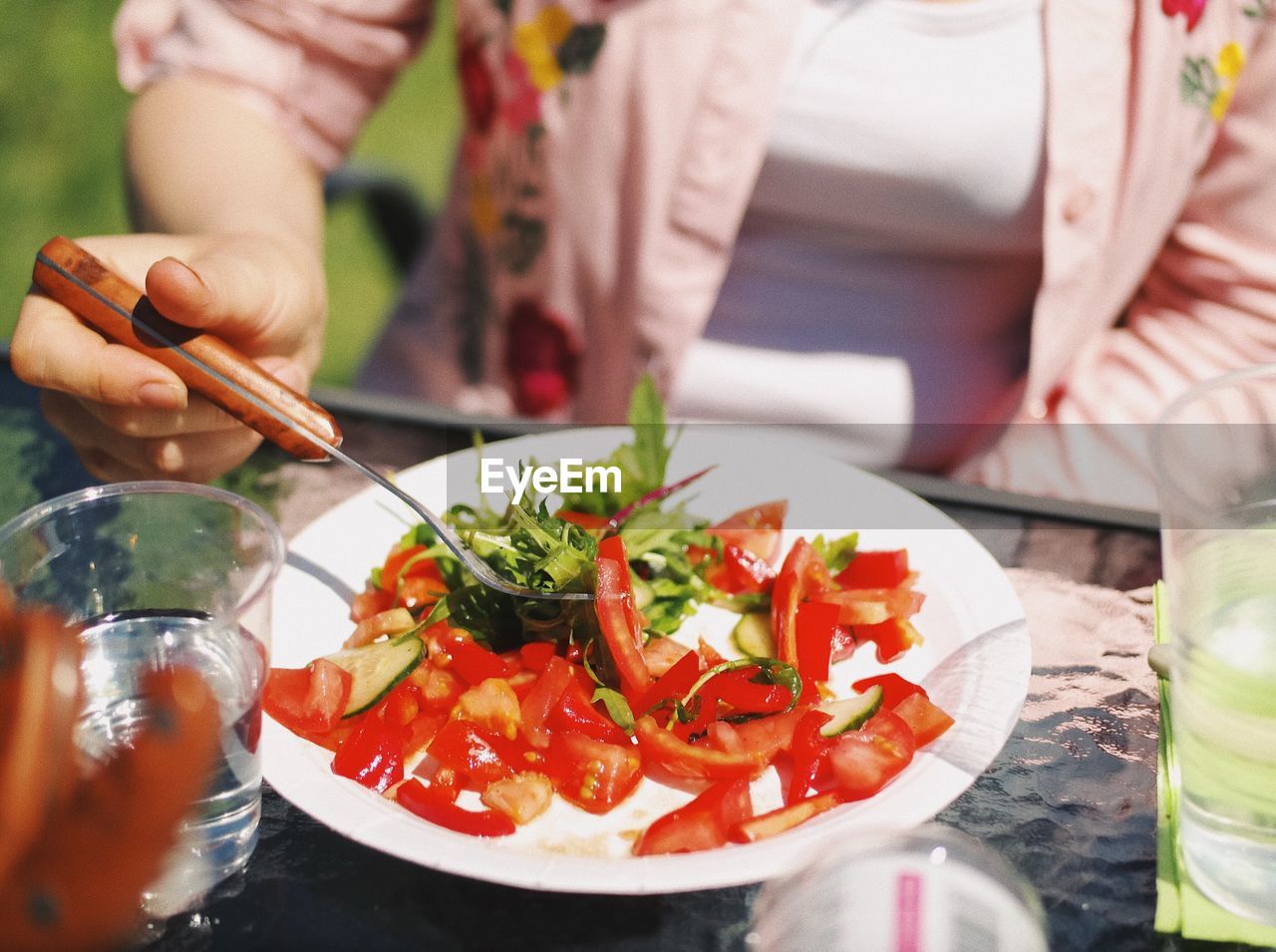 Close-up of woman having salad on table