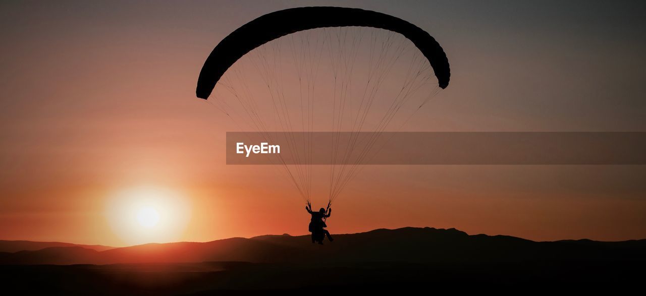 SILHOUETTE PERSON PARAGLIDING AGAINST SKY