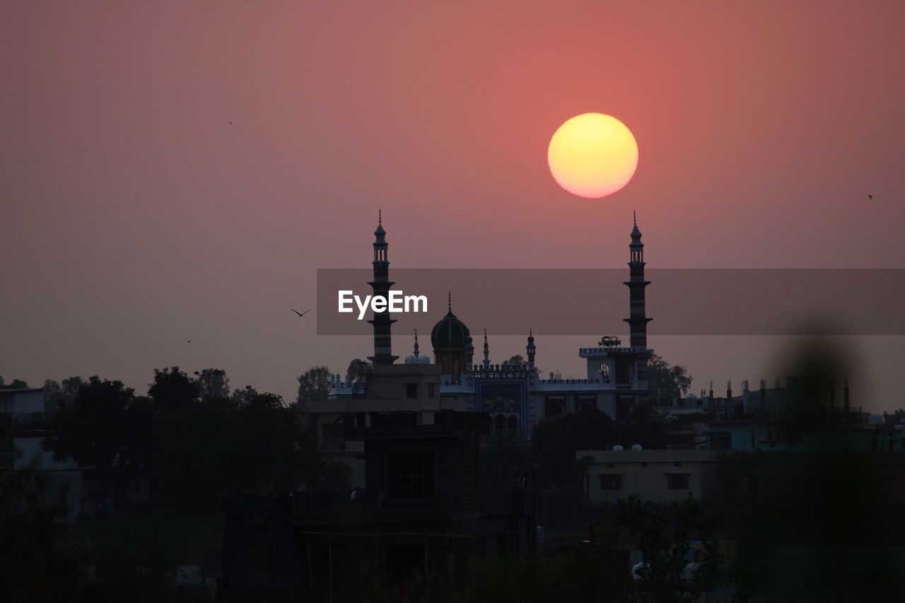 Silhouette of buildings against sky during sunset